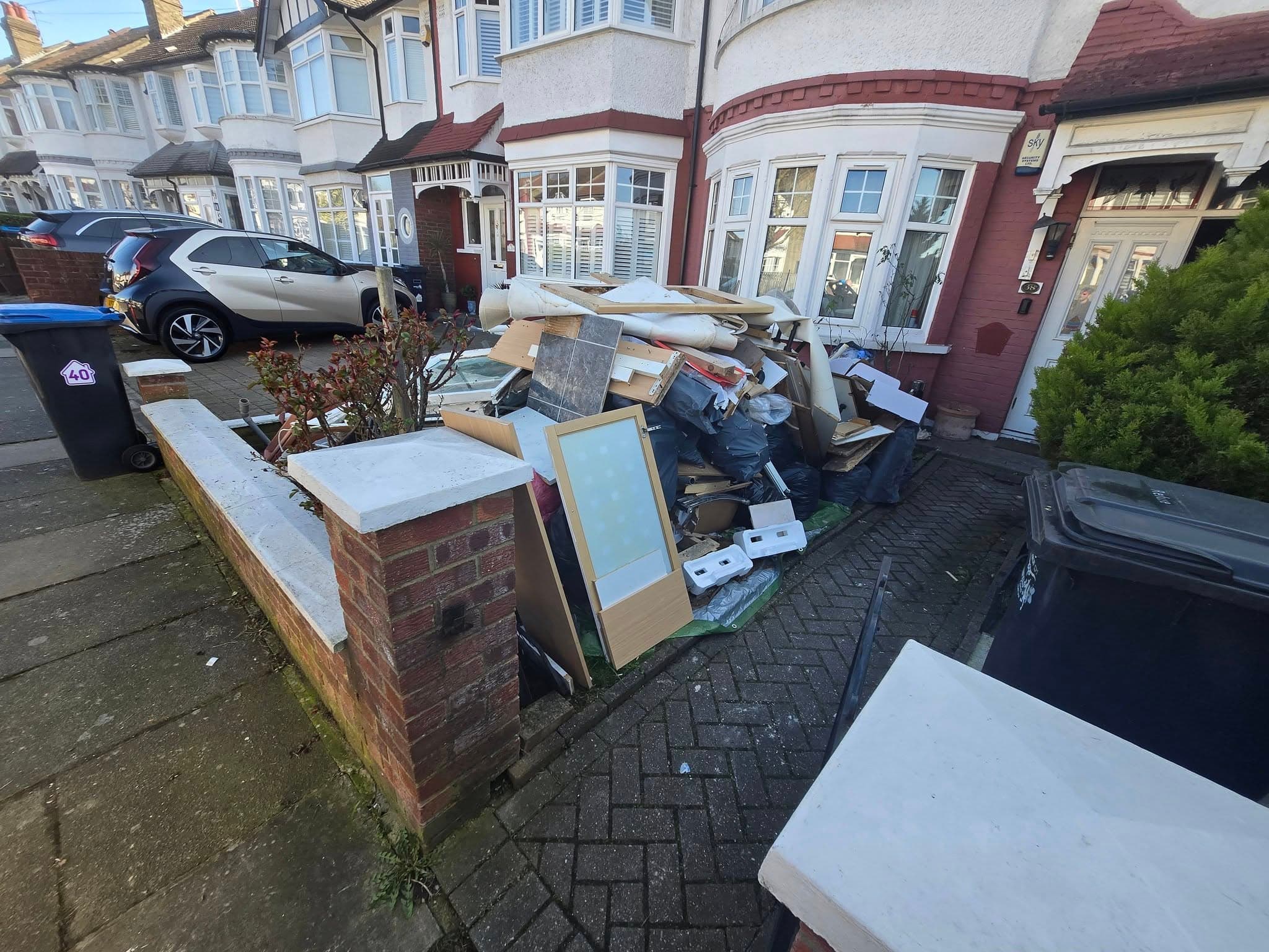 Front garden full of waste, old furniture and debris before clearance